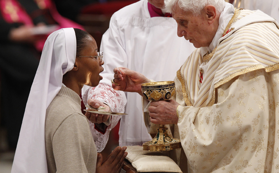 POPE DISTRIBUTES COMMUNION AS HE CELEBRATES CHRISTMAS EVE MASS IN ST. PETER'S BASILICA AT VATICAN